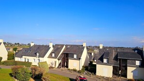 A row of uniform houses with sloped roofs and small front yards. - Bright apartment between port and beaches (Arzon)