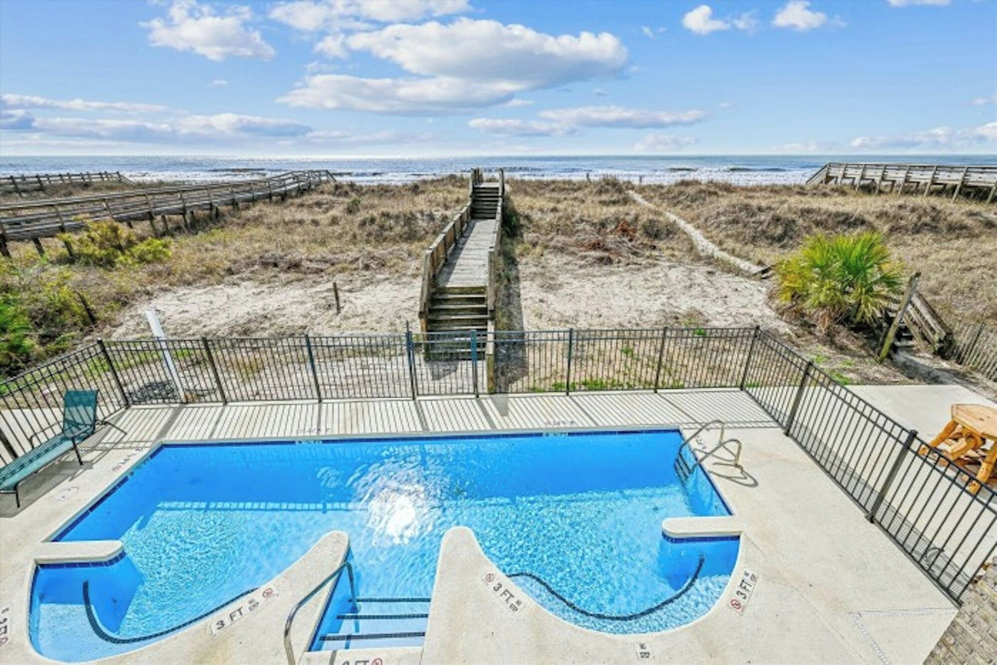 A swimming pool with a view of the beach and ocean.