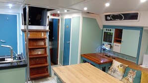 Une cuisine de taille réduite avec une table en bois, un évier et une porte bleue.