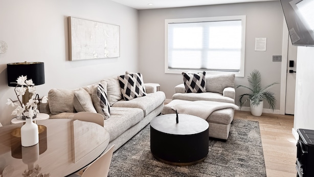 A modern living room with a sofa, a coffee table, and a TV.