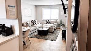 A modern living room with a sofa, coffee table, and a large window.