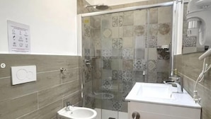 Une salle de bain moderne équipée d’une douche, de toilettes et d’un lavabo.