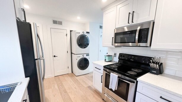 A modern kitchen with stainless steel appliances, a microwave, oven, and a dishwasher. - TownHome 3blks Boardwalk uB (Virginia Beach)