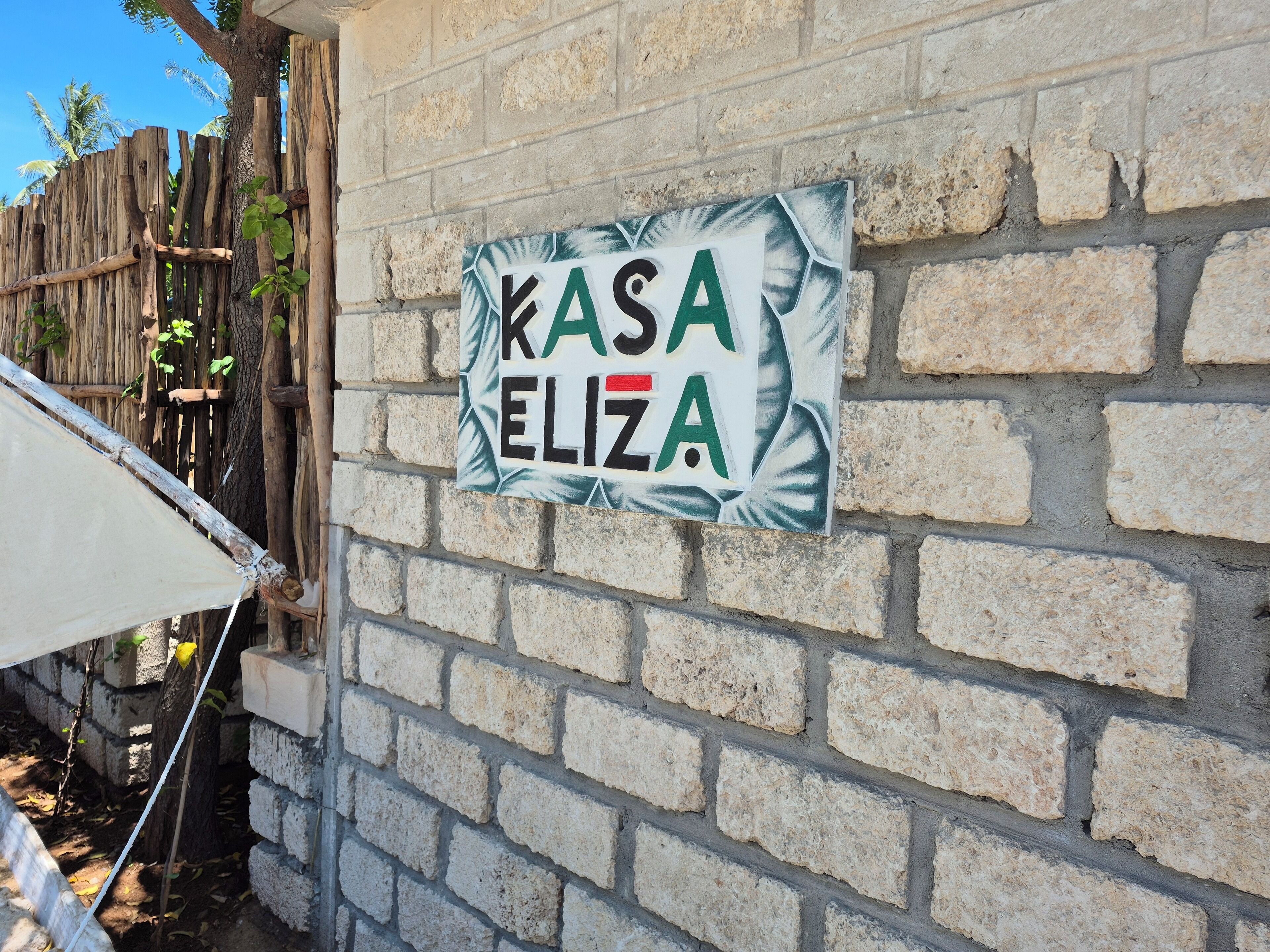 Une affiche sur un mur de briques où l’on peut lire : « KASA ELIZA ».