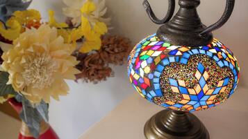 A mosaic lamp with a metal stand, placed on a table.