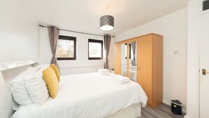A bedroom with a bed, a wardrobe, and a window.