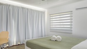 A bedroom with a bed, a chair, a window with blinds, and a ceiling fan. - KITE BEACH HOTEL Two Story  2 /2 Oceanfront Apt with large Oceanfront Terrace (Puerto Plata Province)