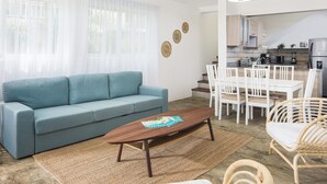 A modern living room with a sofa, coffee table, and dining area. - KITE BEACH HOTEL Two Story  2 /2 Oceanfront Apt with large Oceanfront Terrace (Puerto Plata Province)