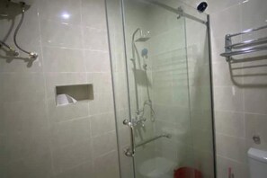 Enjoy a refreshing shower experience with a handheld showerhead and rain showerhead in this bathroom.