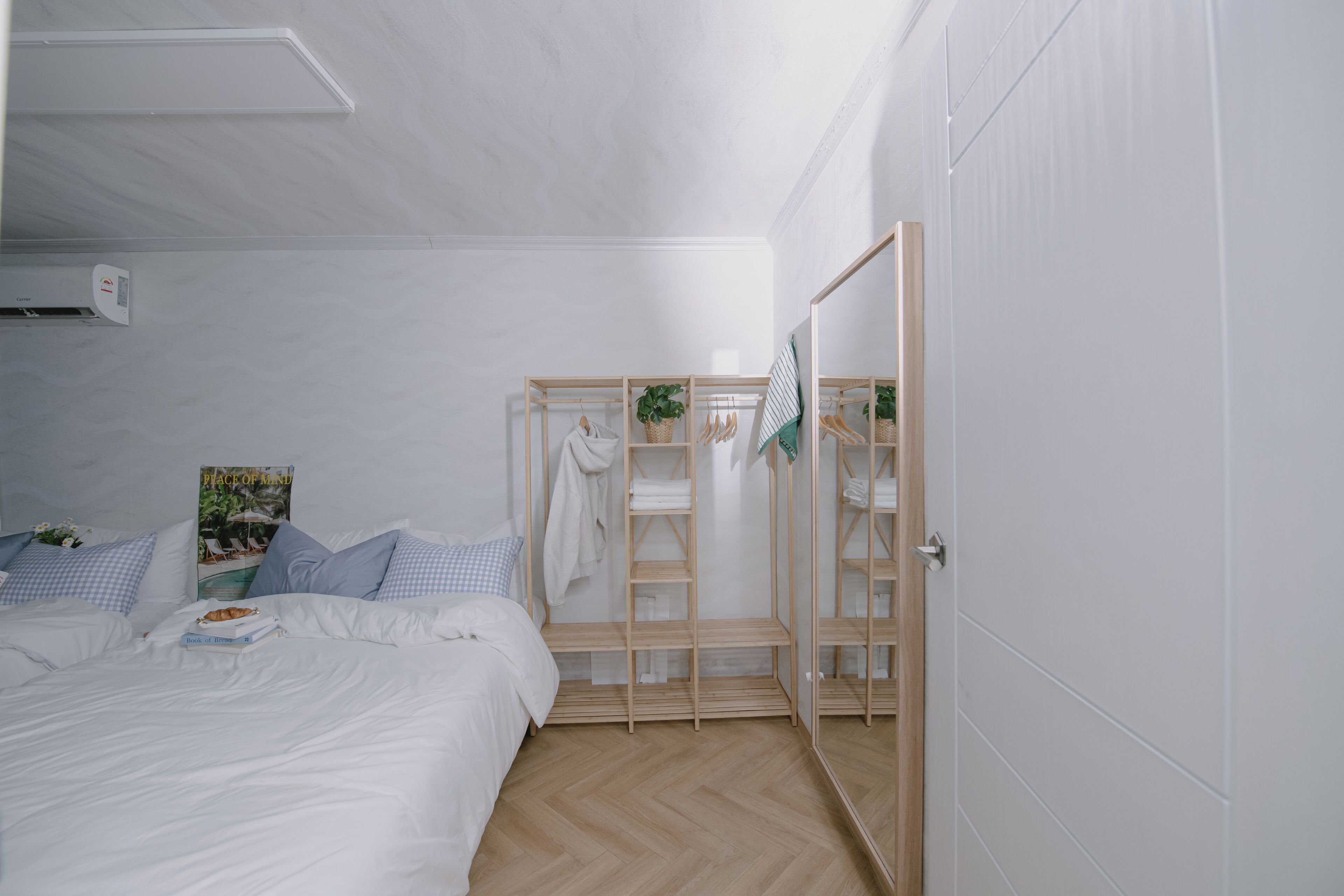 Ein Schlafzimmer mit Bett, Kleiderschrank und Spiegel.