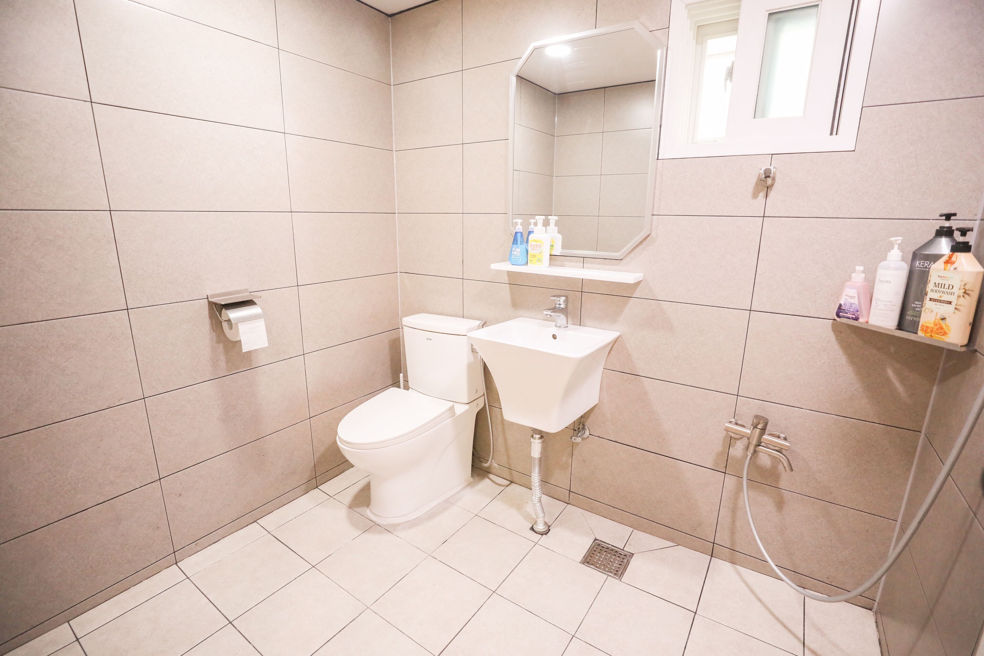 A modern bathroom with a toilet, sink, and shower.
