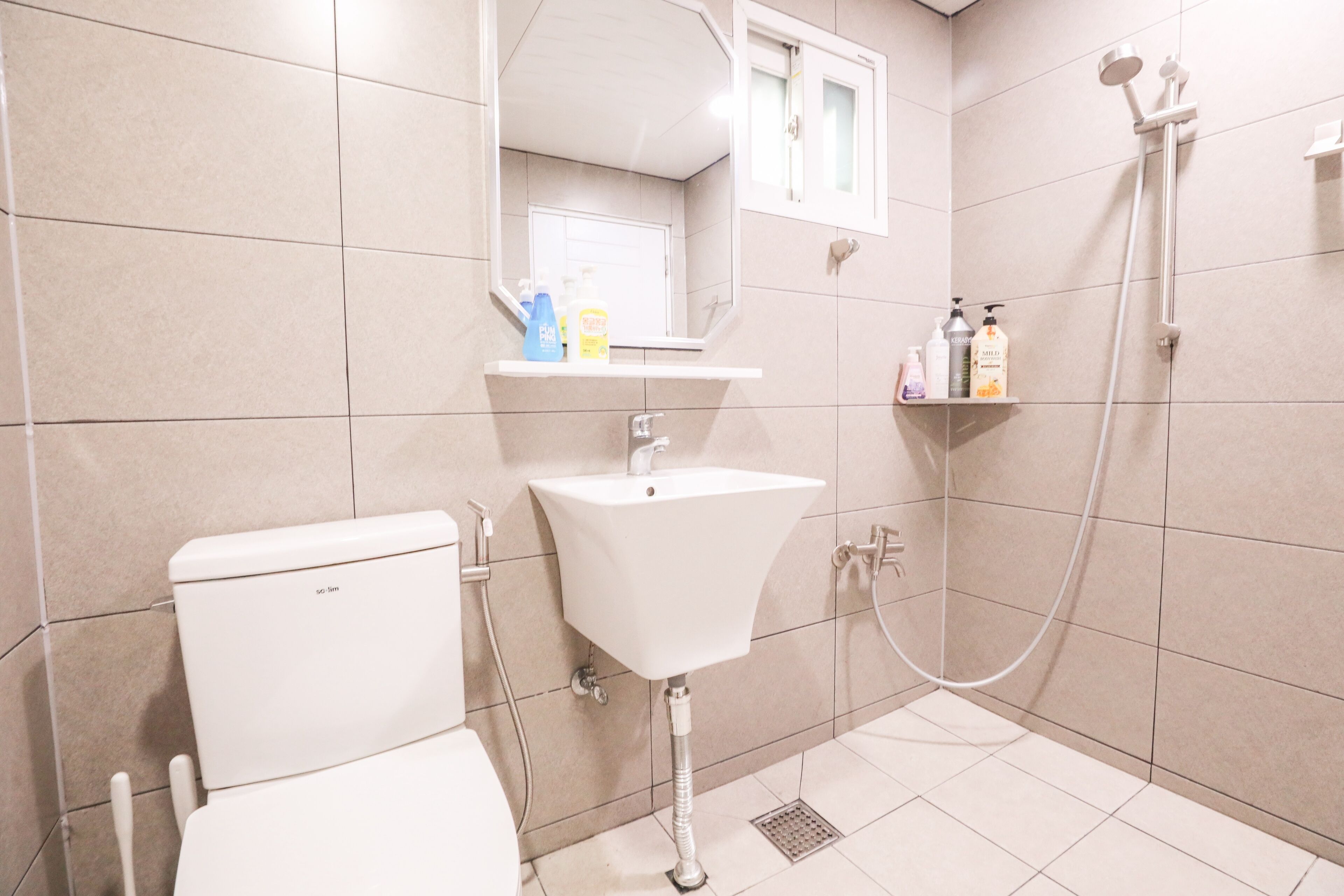 A bathroom with a toilet, sink, and shower.