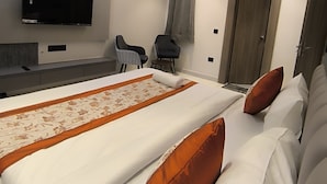 Ein modernes Hotelzimmer mit einem großen Bett, einem Flachbildfernseher, einer Klimaanlage und einem Deckenventilator.