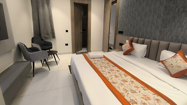 Ein modernes Hotelzimmer mit einem großen Bett, einem kleinen Schreibtisch und einem Stuhl.