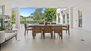 Un vaste espace dédié à la salle à manger, comprenant une grande table et des chaises, un canapé et une plante en pot.