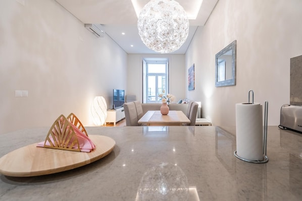 Relax in a spacious living area with a large chandelier, flat-screen TV, and comfortable seating.