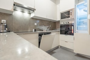 Enjoy cooking in this well-equipped kitchen with a stainless steel range hood, dishwasher, and double oven.