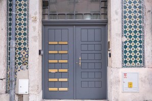 Stylish entrance with a modern door featuring gold accents and a decorative tile pattern.
