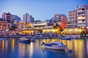 Enjoy waterfront dining and socializing at Dolce Vita, surrounded by modern buildings and scenic views.