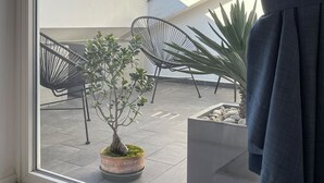 A view from a window with a view of a balcony area, including chairs and potted plants. - Pliny Suite 33 -N.7- (Milano)