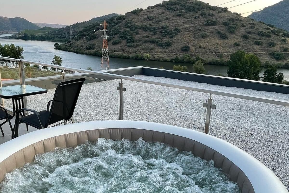 Un jacuzzi con vistas a un río y colinas.
