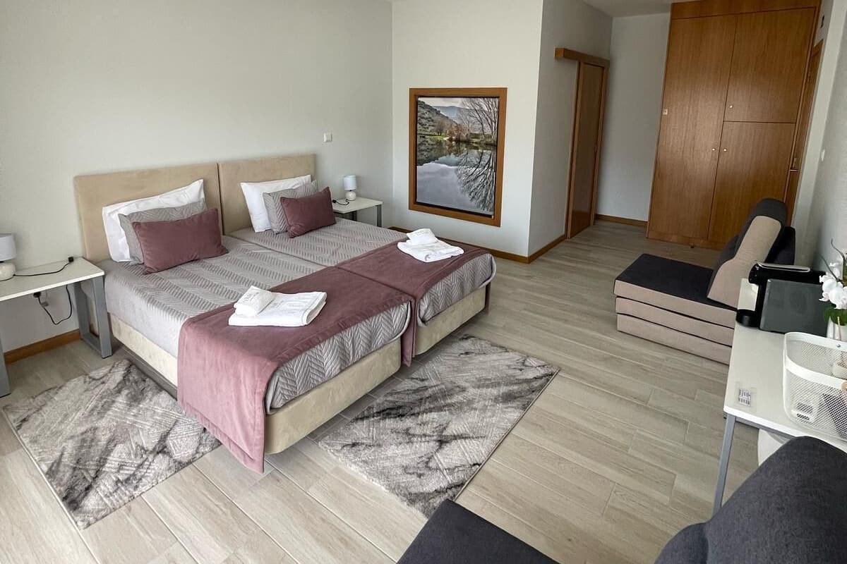 Un dormitorio moderno con cama, mesitas de noche, escritorio, silla y armario.