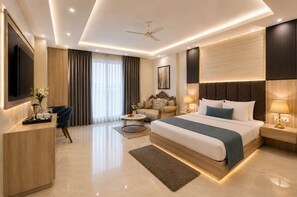 Une chambre d’hôtel moderne dotée d’un grand lit, d’un bureau avec un téléviseur à écran plat, d’un canapé et d’un ventilateur de plafond.