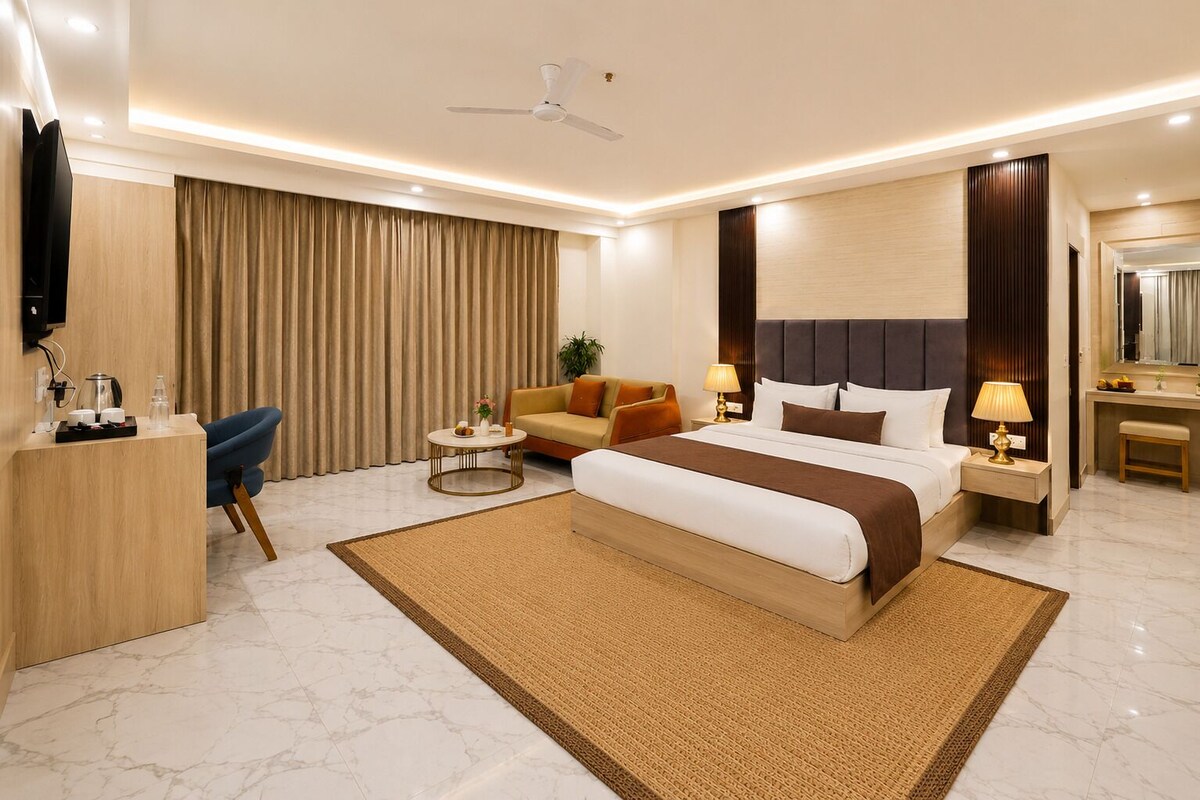Une chambre d’hôtel moderne équipée d’un grand lit, d’un bureau, d’une chaise, d’une télévision et d’un ventilateur de plafond.