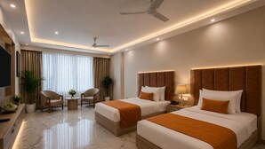 A hotel room with two beds, a TV, a desk, a chair, and a plant. - Hotel West End Mahipalpur Delhi IGI (New Delhi)