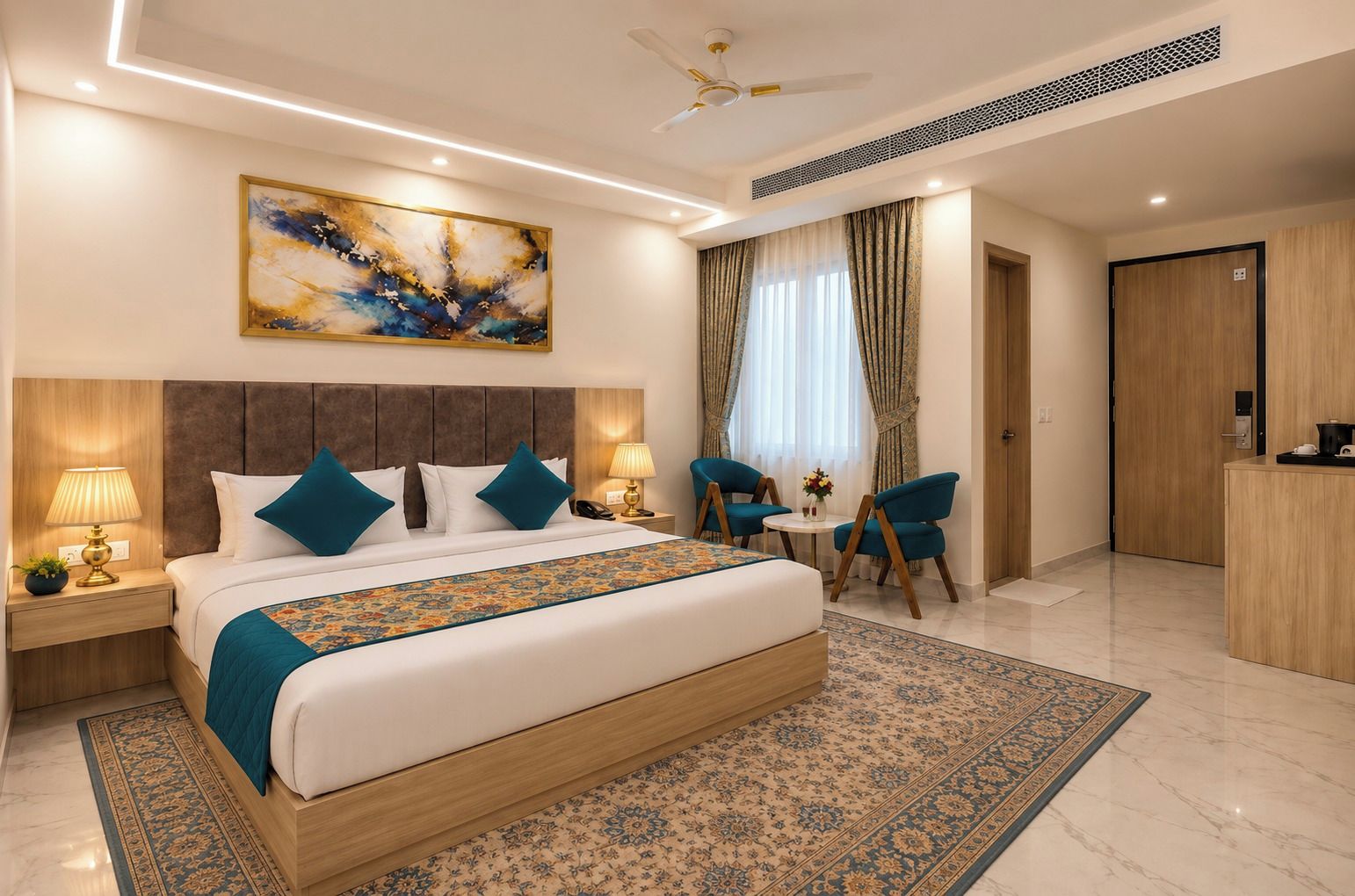 Une chambre d’hôtel avec un grand lit, deux tables de chevet, un bureau, une chaise, un ventilateur de plafond et un tableau au mur.