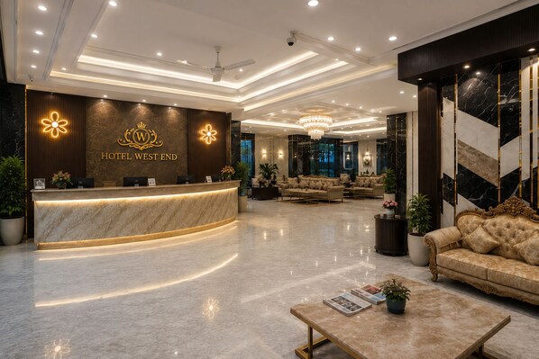 Un hall d’hôtel comprenant un comptoir d’accueil, un espace salon et un lustre.