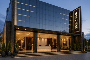 A modern hotel with a glass facade, a reception area, and a sign that reads 'WEST END'. - Hotel West End Mahipalpur Delhi IGI (New Delhi)