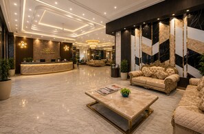 A hotel lobby with a reception desk, plush seating, and a chandelier. - Hotel West End Mahipalpur Delhi IGI (New Delhi)