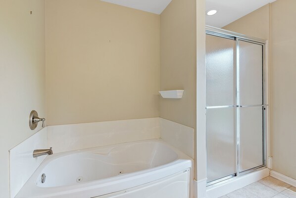 A bathroom with a bathtub, a shower enclosure, and a toilet.
