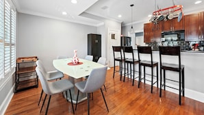 A modern kitchen with wooden cabinets, a microwave, and a hanging pot rack.