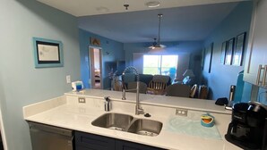 A modern kitchen with a double sink, dark cabinets, and a light countertop.