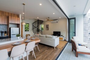 A modern living space with a kitchen, dining area, and seating area.