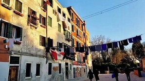 A multi-story building with balconies and laundry hanging outside.