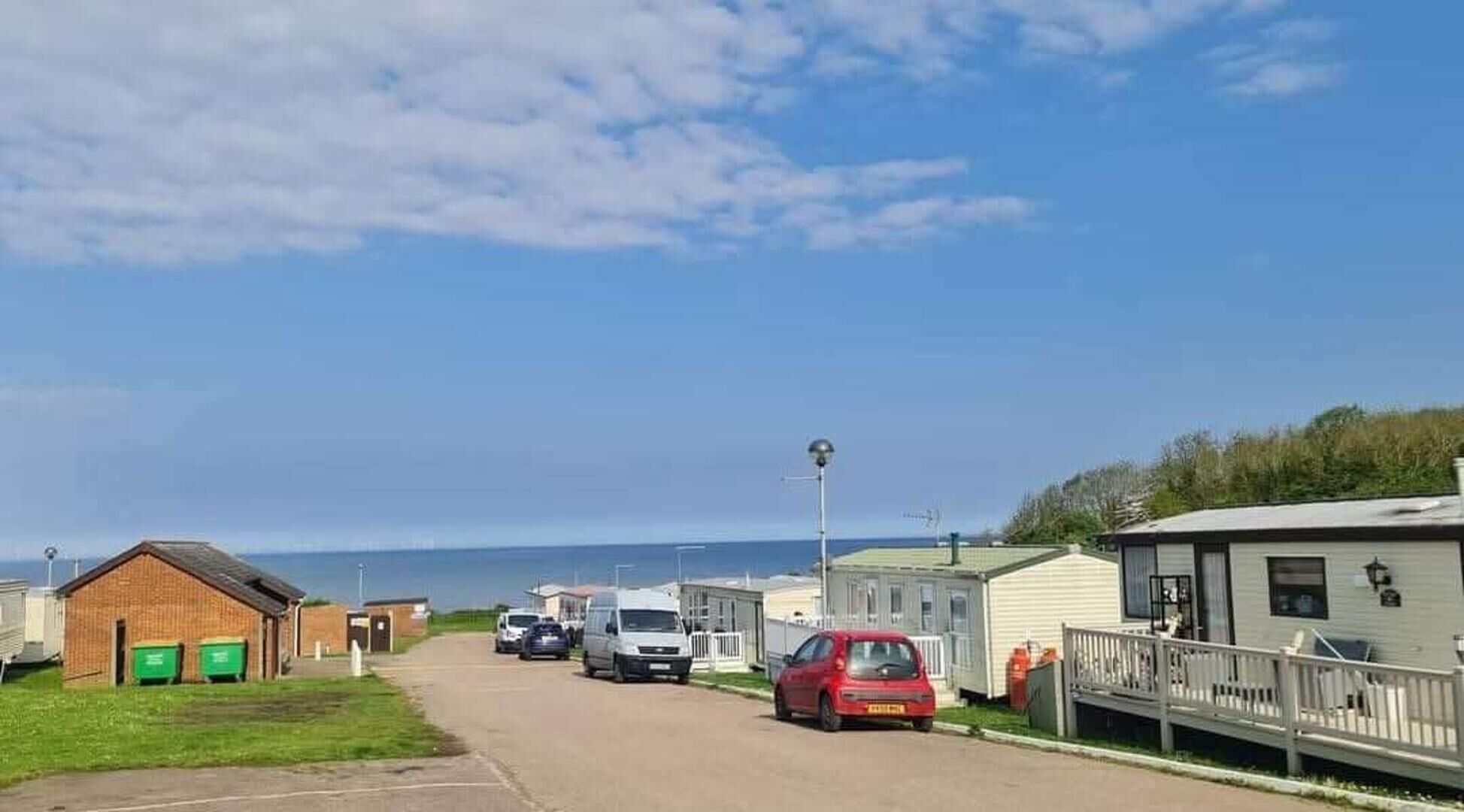 A caravan park with mobile homes, a road, and a clear sky.