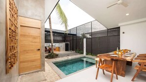 A modern outdoor space with a pool, wooden furniture, and a ceiling fan. - Casa Usure – Huetar-Inspired Beachside Haven (Provincia de Puntarenas)