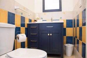 A bathroom with a toilet, a sink, and a cabinet.