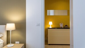 A room with a bedside lamp, a dresser, and a mirror on the wall. - Il Mincio - Peschierahome (Peschiera del Garda)