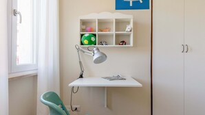 A room with a desk, chair, and a shelf with toys. - I Voltoni - PeschieraHome (Peschiera del Garda)
