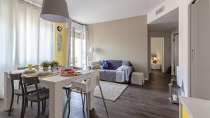 A modern living room with a dining area, a sofa, and a lamp. - La Rocca - Peschierahome (Peschiera del Garda)