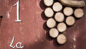 Une enseigne en bois rustique portant le numéro 1 et l’inscription « La Rondinella » peinte dessus.