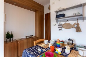 Enjoy meals in this cozy dining area with a wooden table, comfortable chairs, and a warm atmosphere.