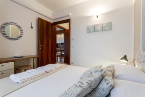 Cozy retreat with a neatly made bed, dining area, and workspace.