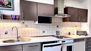 A modern kitchen with stainless steel appliances, a microwave, and a built-in oven. - Apartment GoodTimes, ground floor, 2 x 50" TV, Netflix, south-facing terrace w. Access to the parking lot (Aarbergen)