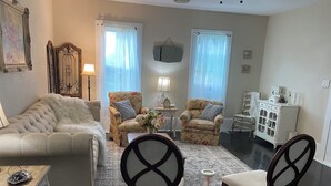 A living room with a sofa, two armchairs, a coffee table, a side table, a lamp, and a cabinet. - Charming 3-bedroom country cottage on a 
Small  pond (Bellville)