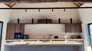 Une cuisine moderne avec des meubles en bois, un îlot central et des luminaires suspendus.